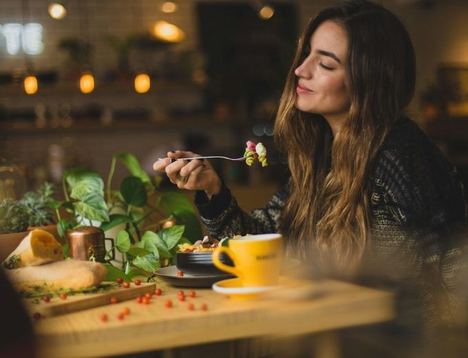 Mujer desayunando con calma, relación sana con la comida