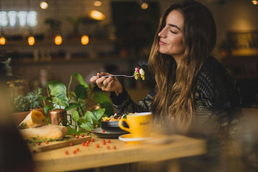 Mujer desayunando con calma, relación sana con la comida